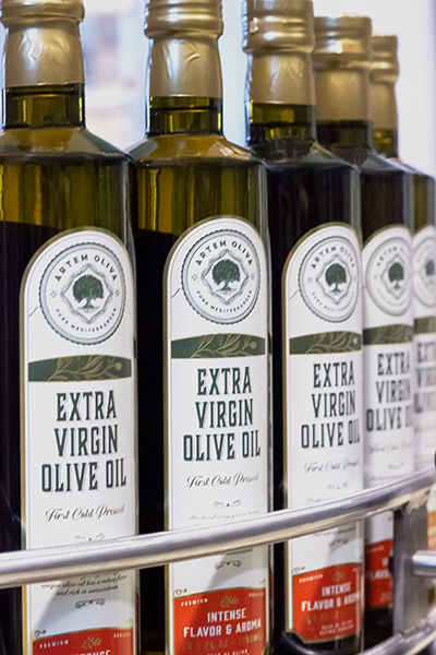 5 Glass Bottles of Extra Virgin Olive Oil that are Labeled Wirth Artem Oliva Brand